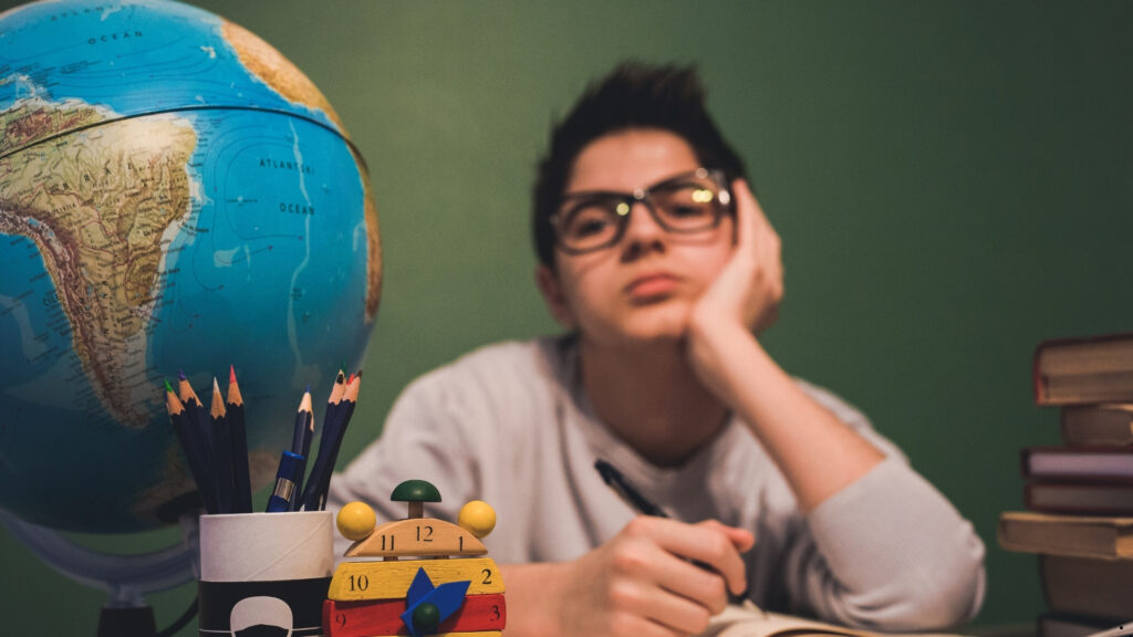 Παιδί ξαπλωμένο σε κρεβάτι, με ροζ μπλούζα, ξυπνάει και τρίβει τα μάτια του — ενδεικτικό στιγμιότυπο παιδικής ρουτίνας ύπνου.